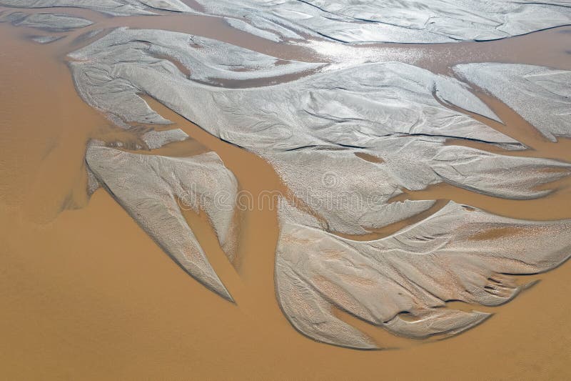 Beautiful riverbed in sunlight, a natural pattern of alluvial sediment. Beautiful riverbed in sunlight, a natural pattern of alluvial sediment