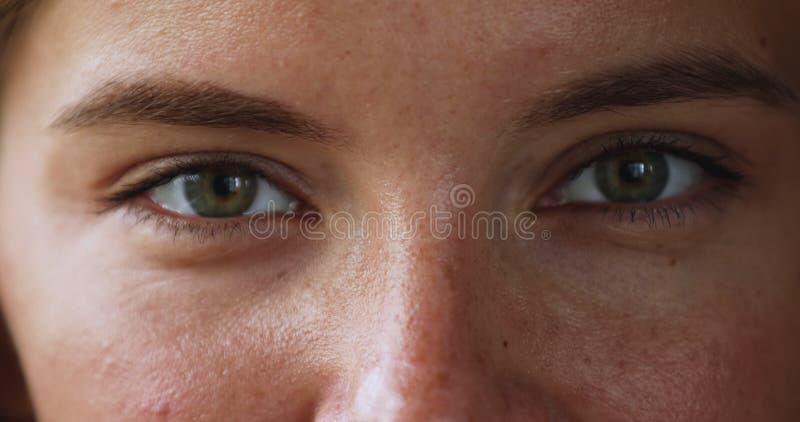 Belos olhos verdes de uma jovem fêmea sorridente olhando para a câmera