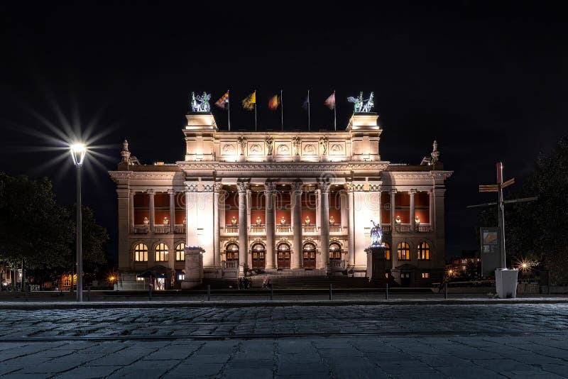 Belyst kungligt museum för konstnärer med landflaggor nattetid
