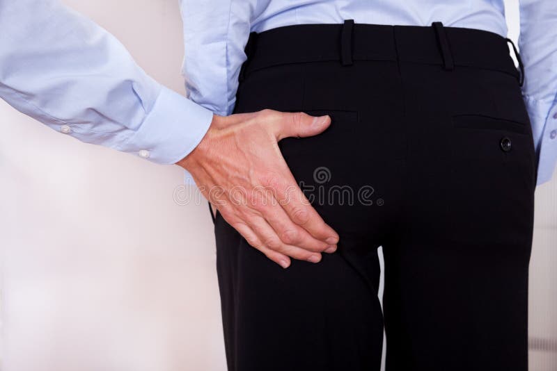Conceptual image of harassment in the workplace with a man stretching out his hand to touch a colleagues bottom. Conceptual image of harassment in the workplace with a man stretching out his hand to touch a colleagues bottom