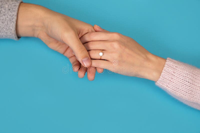 Bemannen Sie das Halten Eheringhanddes blauen Hintergrundfreundinfreundantrag-Liebesgeschichtevalentinsgrußes stockfotos Bemannen Sie das Halten Eheringhanddes blauen Hintergrundfreundinfreundantrag-Liebesgeschichtevalentinsgrußes stockfotos