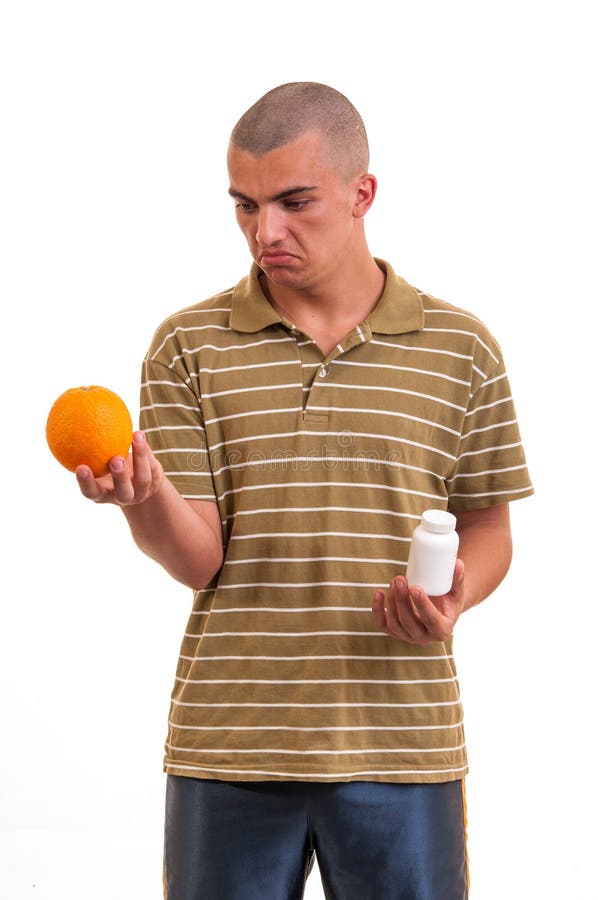 Bemannen Sie das Halten einer Orange in einer Hand und der Pillen in anderen stockbild Bemannen Sie das Halten einer Orange in einer Hand und der Pillen in anderen stockbild