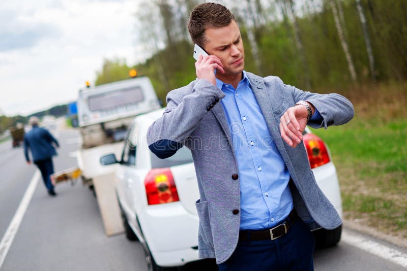 Bemannen Sie das Nennen während der Abschleppwagen, der sein defektes Auto aufhebt stockfotos Bemannen Sie das Nennen während der Abschleppwagen, der sein defektes Auto aufhebt stockfotos