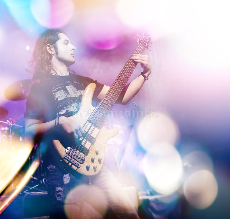 Bemannen Sie das Spielen der Bass-Gitarre in der Livekonzertreihenfolge Weinlesemikrofon und -öffentlichkeit lizenzfreie stockfotos Bemannen Sie das Spielen der Bass-Gitarre in der Livekonzertreihenfolge Weinlesemikrofon und -öffentlichkeit lizenzfreie stockfotos