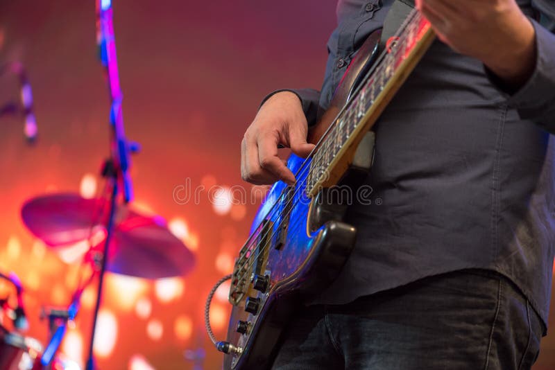 Bemannen Sie das Spielen der Gitarre auf einem Stadiumsmusicalkonzert stockfoto Bemannen Sie das Spielen der Gitarre auf einem Stadiumsmusicalkonzert stockfoto