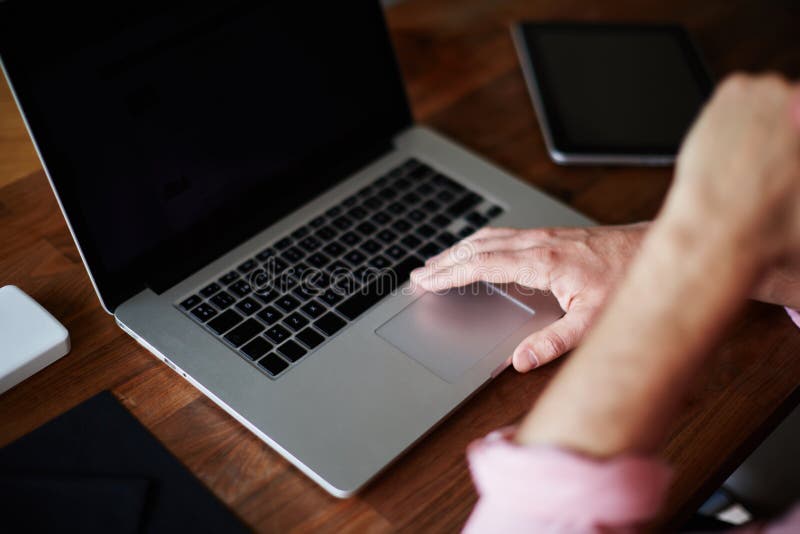 Bemannen Sie den Gebrauchslaptop, der am hölzernen Schreibtisch mit der Hand gegen seinen Mund sitzt lizenzfreie stockbilder Bemannen Sie den Gebrauchslaptop, der am hölzernen Schreibtisch mit der Hand gegen seinen Mund sitzt lizenzfreie stockbilder