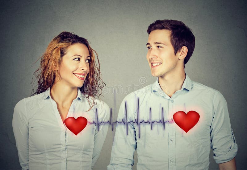 Bemannen Sie die Frau, die einander mit den roten Herzen betrachtet, die durch Kardiogramm verbunden werden