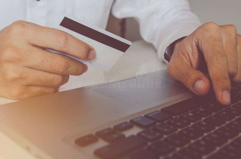 Bemannen Sie die Hand, die Kreditkarte hält und den Laptop verwendet, der on-line--paym macht lizenzfreies stockbild Bemannen Sie die Hand, die Kreditkarte hält und den Laptop verwendet, der on-line--paym macht lizenzfreies stockbild