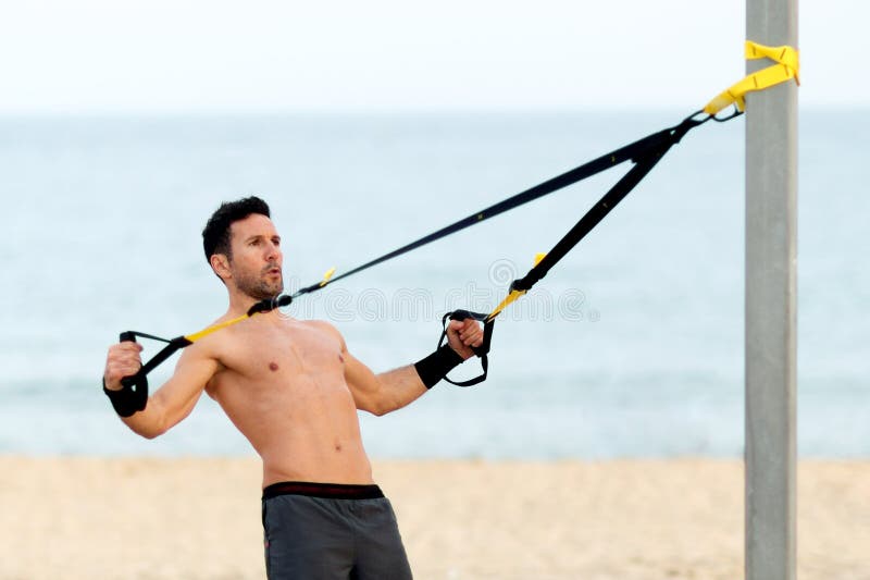 bemannen Sie die Herstellung von Kasten trx Übung auf dem Strand stockfotografie bemannen Sie die Herstellung von Kasten trx Übung auf dem Strand stockfotografie