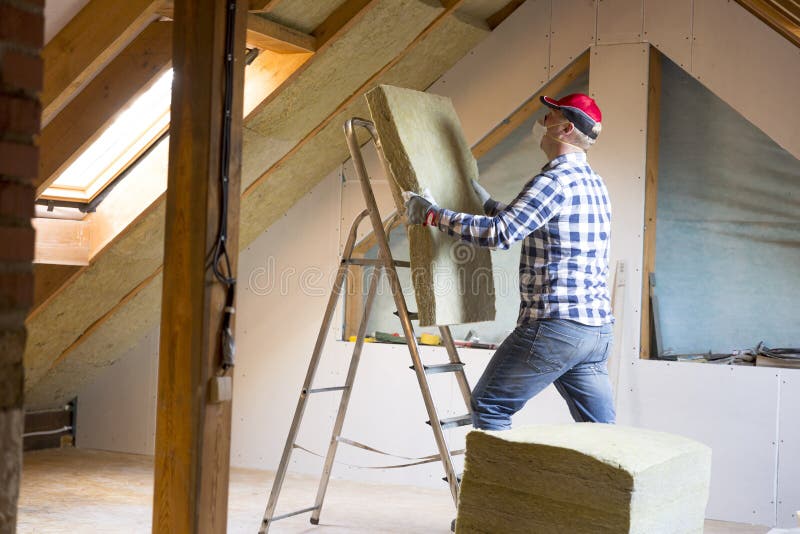 Bemannen Sie die Installierung der thermischen Dachdämmschicht - unter Verwendung des Minerals flehen Sie an stockfoto Bemannen Sie die Installierung der thermischen Dachdämmschicht - unter Verwendung des Minerals flehen Sie an stockfoto