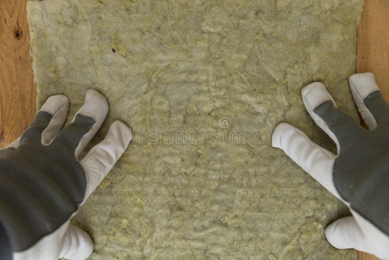 Bemannen Sie die Installierung der thermischen Dachdämmschicht - unter Verwendung des Minerals flehen Sie an lizenzfreies stockbild Bemannen Sie die Installierung der thermischen Dachdämmschicht - unter Verwendung des Minerals flehen Sie an lizenzfreies stockbild