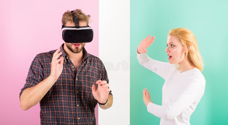 Bemannen Sie mit einbezogenes Videospiel VR Gläser während Mädchenversuch, um ihn oben aufzuwecken Videospiel gefangengenommene F lizenzfreies stockbild Bemannen Sie mit einbezogenes Videospiel VR Gläser während Mädchenversuch, um ihn oben aufzuwecken Videospiel gefangengenommene F lizenzfreies stockbild