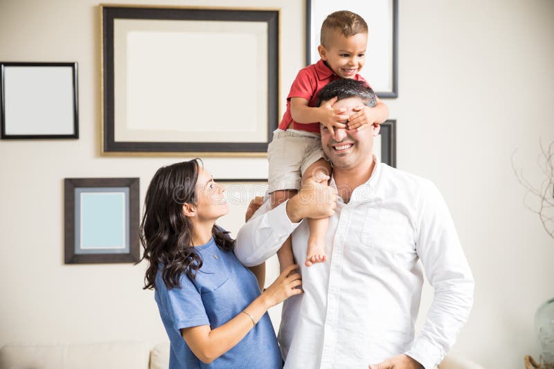 Bemuttern Sie aufpassende spielerische Jungen-Bedeckung, ` s Augen zu Hause hervorzubringen lizenzfreie stockbilder Bemuttern Sie aufpassende spielerische Jungen-Bedeckung, ` s Augen zu Hause hervorzubringen lizenzfreie stockbilder