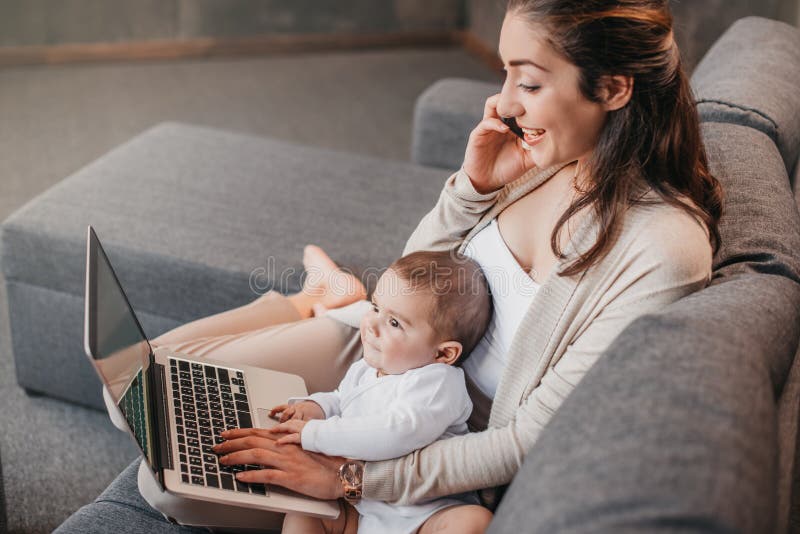Bemuttern Sie das Arbeiten vom Haus und auf Smartphone beim Verbringen von Zeit mit ihrem Baby sprechen