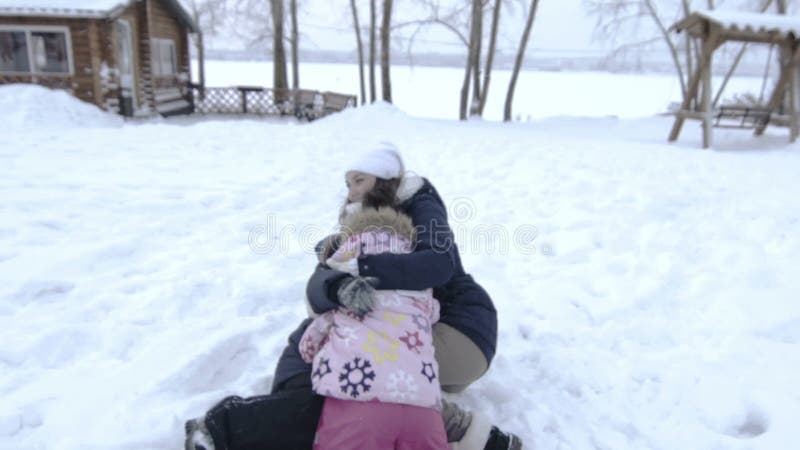 Bemuttern Sie die Tochter und Sohn, die Spaß im Schnee haben Familie, die Winter genießt