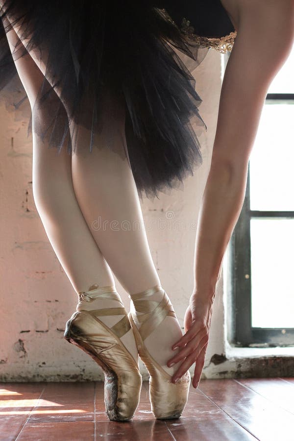Ben av en ballerinacloseup Benen av en ballerina i gammal pointe Repetitionballerina i korridoren Konturljus från fönstret royaltyfria bilder Ben av en ballerinacloseup Benen av en ballerina i gammal pointe Repetitionballerina i korridoren Konturljus från fönstret royaltyfria bilder