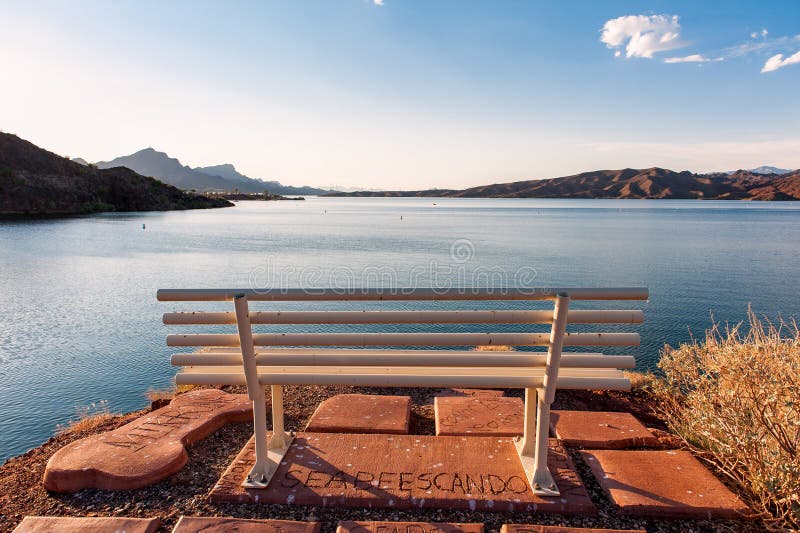 The bench in front of the lake under the blue sky