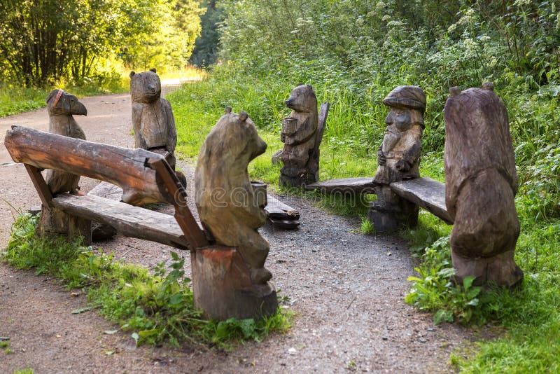 Benches with wooden sculptures of animals on terrenkur health trail along the Belokurikha mountain river