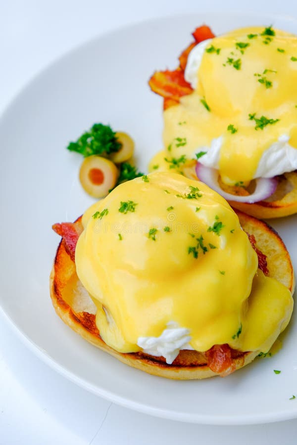 Benedict Eggs on a White Background with Onion and Olives Stock Image