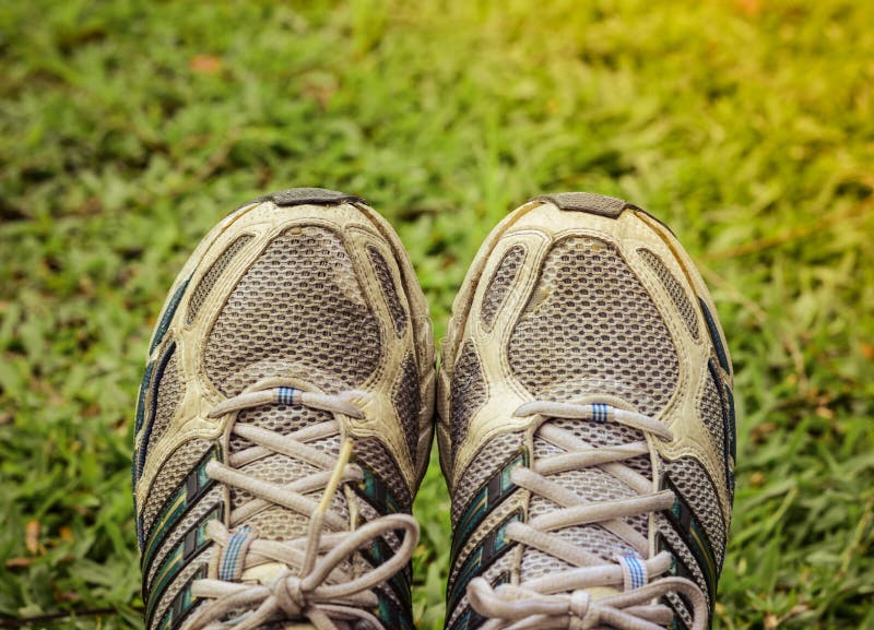 Benutzte Sportschuhe auf Yardhintergrund stockbild Benutzte Sportschuhe auf Yardhintergrund stockbild