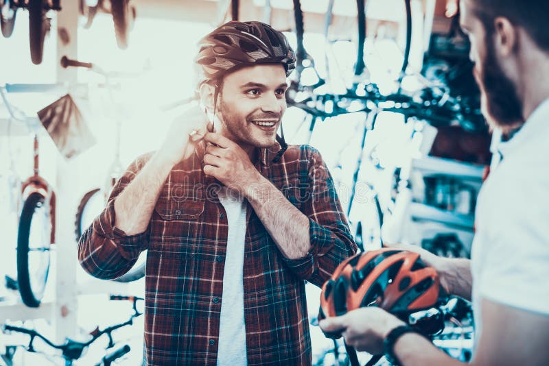 Berater Helps Guy Choose Helmet für Fahrrad-Fahrten stockbilder Berater Helps Guy Choose Helmet für Fahrrad-Fahrten stockbilder