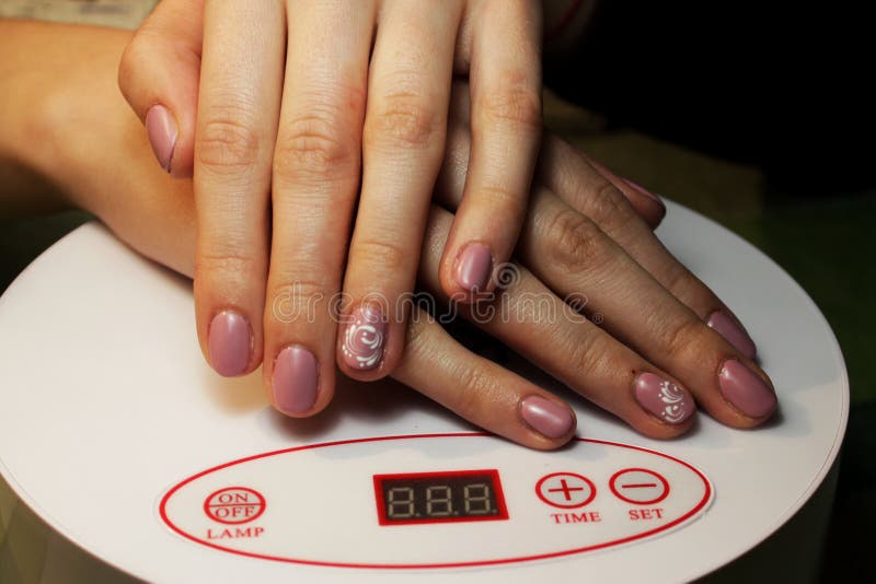 bereiter Maniküreschellack Maniküre durchgeführt vom Studenten Handlüge auf einer speziellen Ultraviolett-Lampe Rosa Mattende mit lizenzfreie stockfotos bereiter Maniküreschellack Maniküre durchgeführt vom Studenten Handlüge auf einer speziellen Ultraviolett-Lampe Rosa Mattende mit lizenzfreie stockfotos