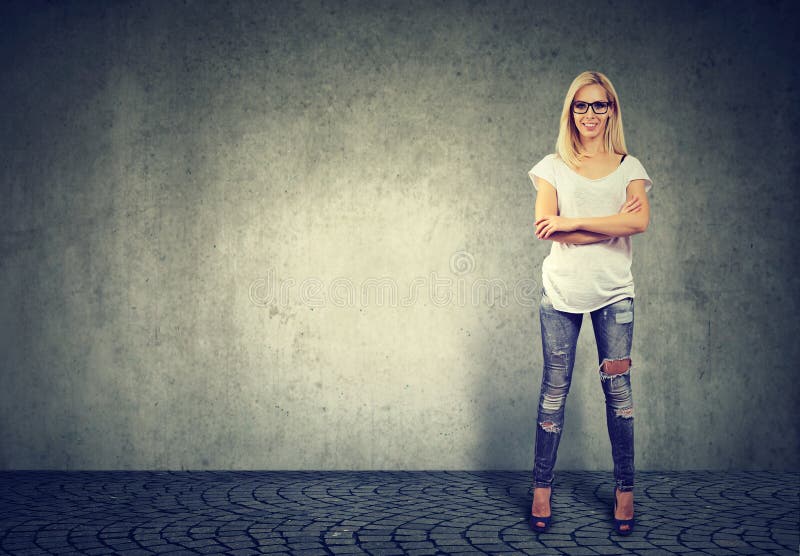 Bereitstehende Betonmauer der jungen überzeugten glücklichen Frau lizenzfreies stockbild Bereitstehende Betonmauer der jungen überzeugten glücklichen Frau lizenzfreies stockbild