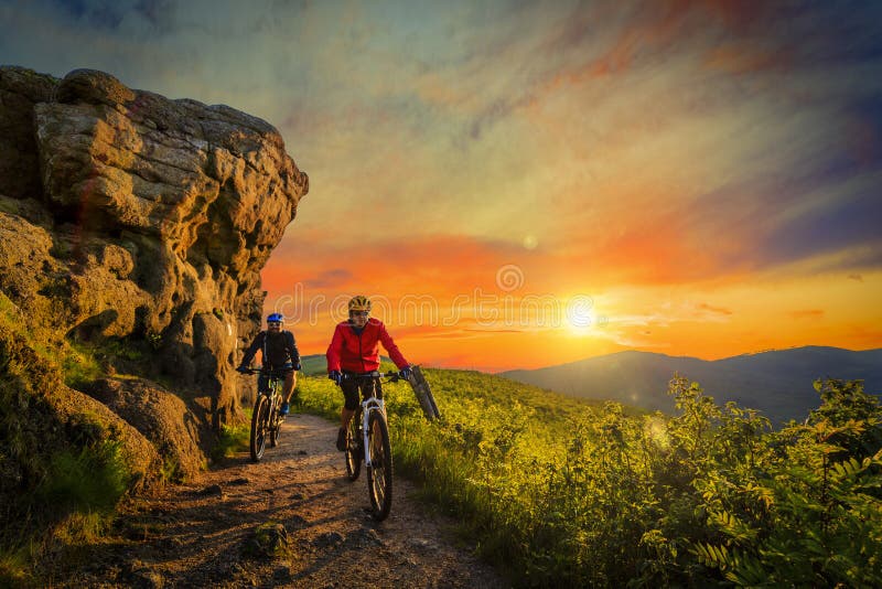 Berg biking vrouwen en personenvervoer op fietsen bij zonsondergangberg