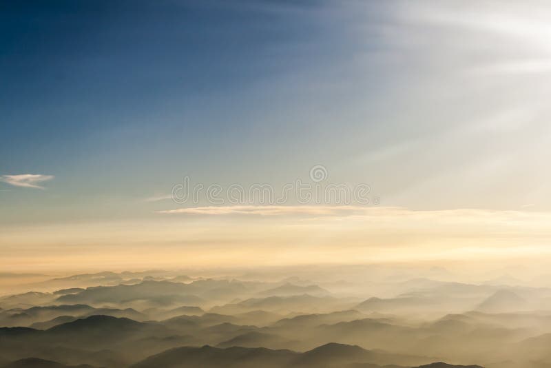 Berg fördunklar blå himmel och dimma som fotograferas från på bergstoppet arkivfoto