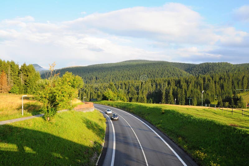 Berg-Tatra-Landschaft mit grünem Wald, blauen Wolken und Wiese Straße in der Mitte lizenzfreie stockfotografie Berg-Tatra-Landschaft mit grünem Wald, blauen Wolken und Wiese Straße in der Mitte lizenzfreie stockfotografie