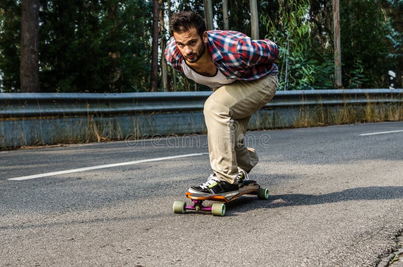 Downhill skateboarder in action on a asphalt road. Downhill skateboarder in action on a asphalt road.