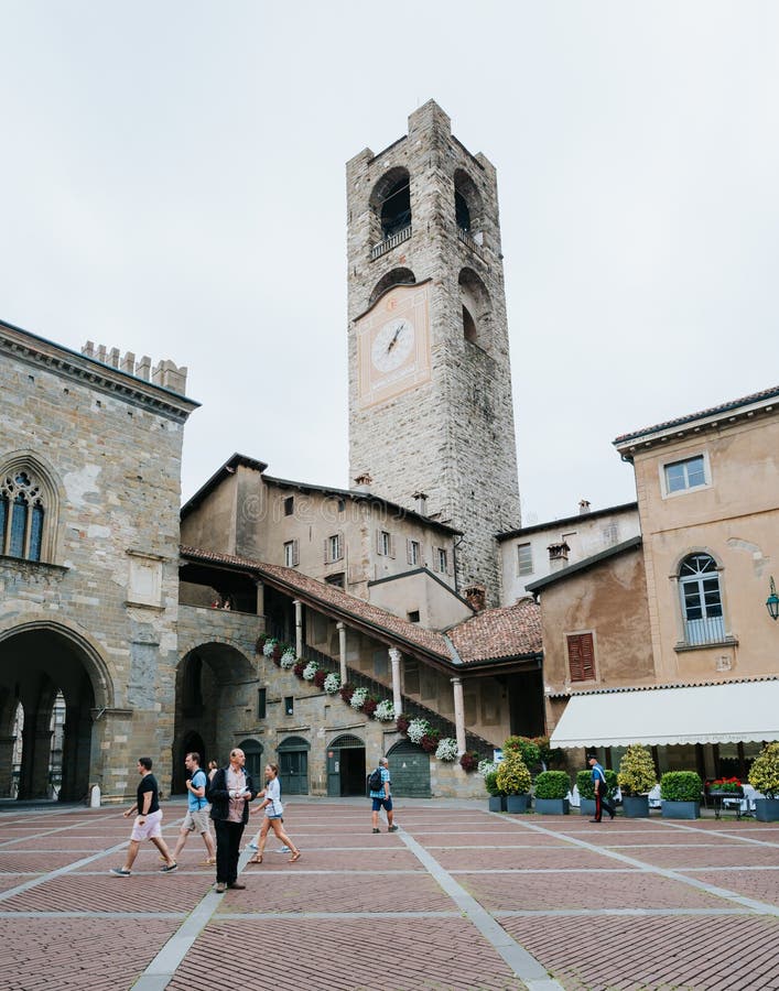 BERGAMO ITALIEN - JUNI 16, 2016: Folk på Piacca Vecchia som är främst av det medborgerliga tornet (Torre Civica Campanone) i CItt royaltyfria bilder BERGAMO ITALIEN - JUNI 16, 2016: Folk på Piacca Vecchia som är främst av det medborgerliga tornet (Torre Civica Campanone) i CItt royaltyfria bilder