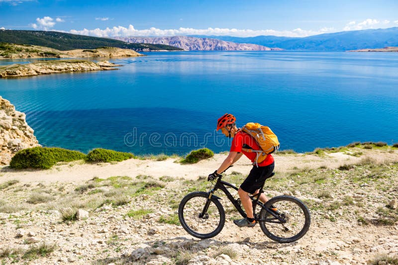 Bergcyklistridning på cykeln i sommarsjösida arkivbild Bergcyklistridning på cykeln i sommarsjösida arkivbild
