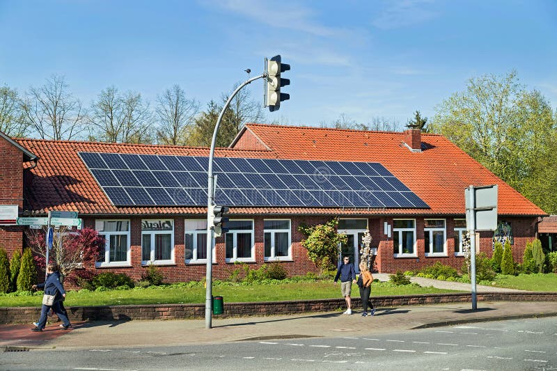 Bergen, Germany - April 30, 2017: Solar energy panel on a house roof on the blue sky background. stock photo Bergen, Germany - April 30, 2017: Solar energy panel on a house roof on the blue sky background. stock photo