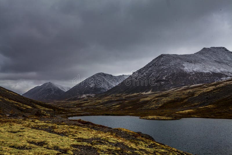 Berglandschap Rakkerland van een bergmeer op een regenachtige herfstdag Eerste sneeuw stock afbeelding Berglandschap Rakkerland van een bergmeer op een regenachtige herfstdag Eerste sneeuw stock afbeelding