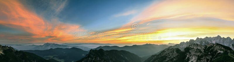 Berglandskap på solnedgången i Julian Alps Fantastisk sikt på färgrika moln och i lager berg fotografering för bildbyråer Berglandskap på solnedgången i Julian Alps Fantastisk sikt på färgrika moln och i lager berg fotografering för bildbyråer