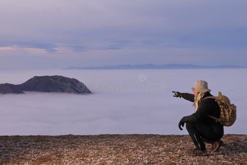 BERGMANN MIT RÜCKPAKET, DER MIT SEINEM FINGER ZU EINEM BERG ZEIGT, UM VON DEN SCHWANGERN ZU ÜBERWINDEN lizenzfreie stockfotografie
