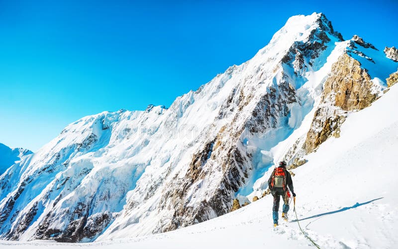 Climber reaches the summit of mountain peak. Climbing and mountaineering sport concept, Nepal Himalayas. Climber reaches the summit of mountain peak. Climbing and mountaineering sport concept, Nepal Himalayas