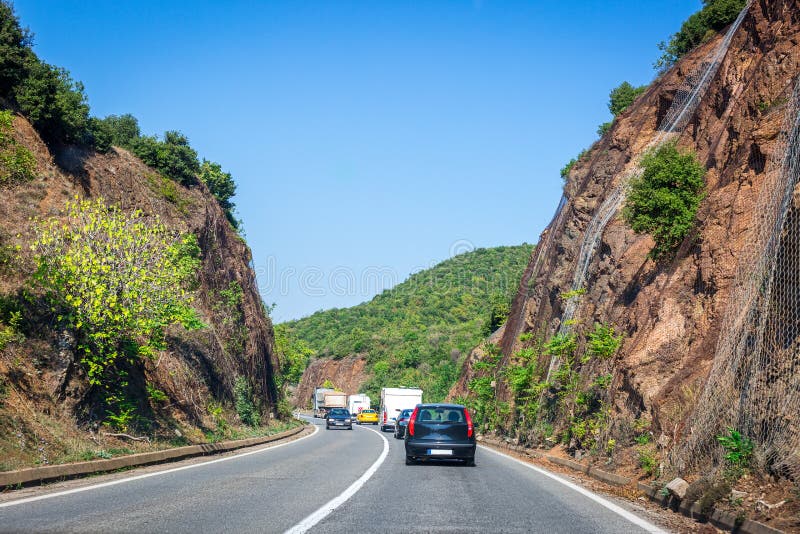 Bergweg in Macedonië Rots door netto die staal wordt beschermd Landschap met kleurrijke heuvels Auto's in opstopping op de weg royalty-vrije stock fotografie Bergweg in Macedonië Rots door netto die staal wordt beschermd Landschap met kleurrijke heuvels Auto's in opstopping op de weg royalty-vrije stock fotografie