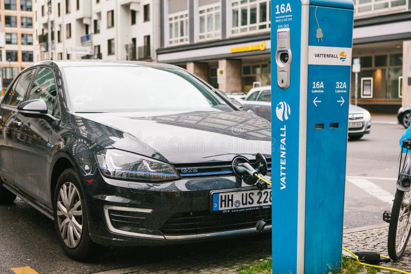 Berlijn, 1 Oktober, 2017: De elektrische auto wordt geladen op een speciale plaats voor het laden van elektrische voertuigen Mode stock afbeelding Berlijn, 1 Oktober, 2017: De elektrische auto wordt geladen op een speciale plaats voor het laden van elektrische voertuigen Mode stock afbeelding