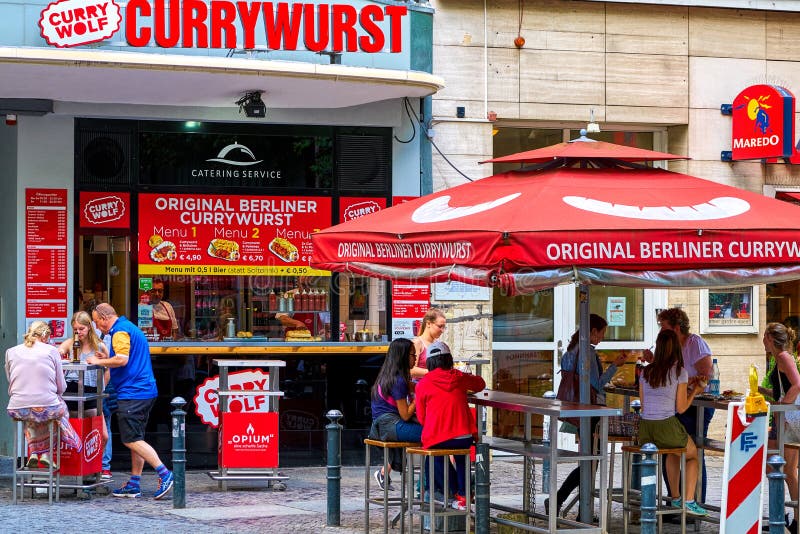 BERLIN TYSKLAND - JUNI 10 2017: En försälja stall med yttersidatabeller av det senaste fastfooddillet i Berlin, arkivbild BERLIN TYSKLAND - JUNI 10 2017: En försälja stall med yttersidatabeller av det senaste fastfooddillet i Berlin, arkivbild
