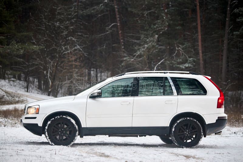 Berlin, Germany - December 4, 2023: Volvo XC90 4.4 v8 1st generation restyling 4WD SUV test drive in winter country road on forest background, left side view. Berlin, Germany - December 4, 2023: Volvo XC90 4.4 v8 1st generation restyling 4WD SUV test drive in winter country road on forest background, left side view.