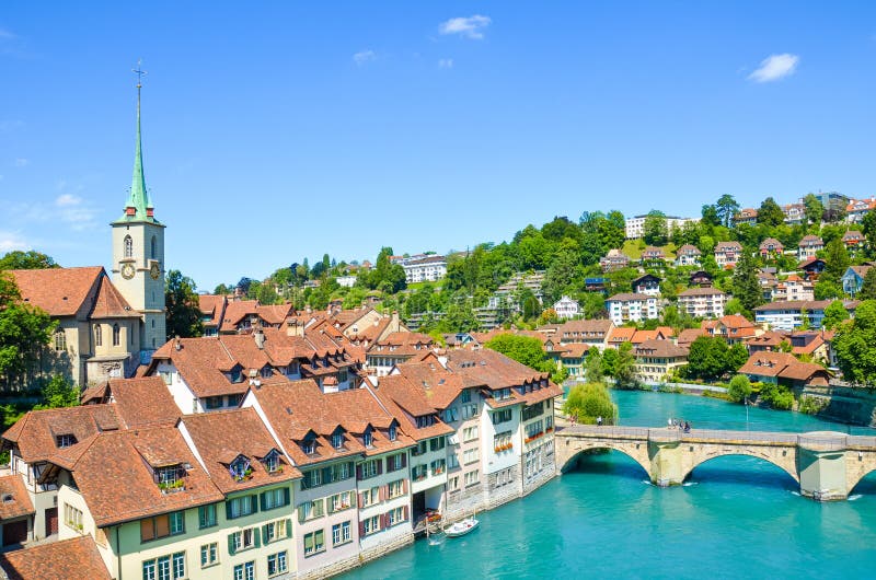 Bern, the capital of Switzerland, with dominant Nydegg Church and historical center located along turquoise Aare River. Bridge over Aare. Tourist destination, local attraction. Swiss city