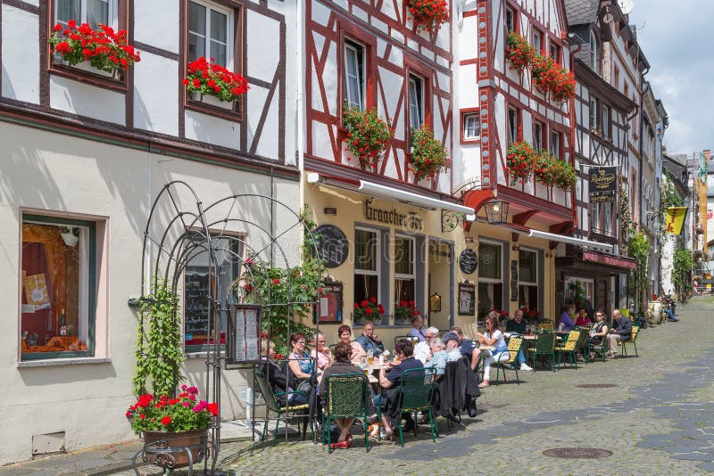 BERNKASTEL TYSKLAND - JULI 21: Historisk mitt av den medeltida staden Bernkastel med okända turister som sitter på flera terrasse