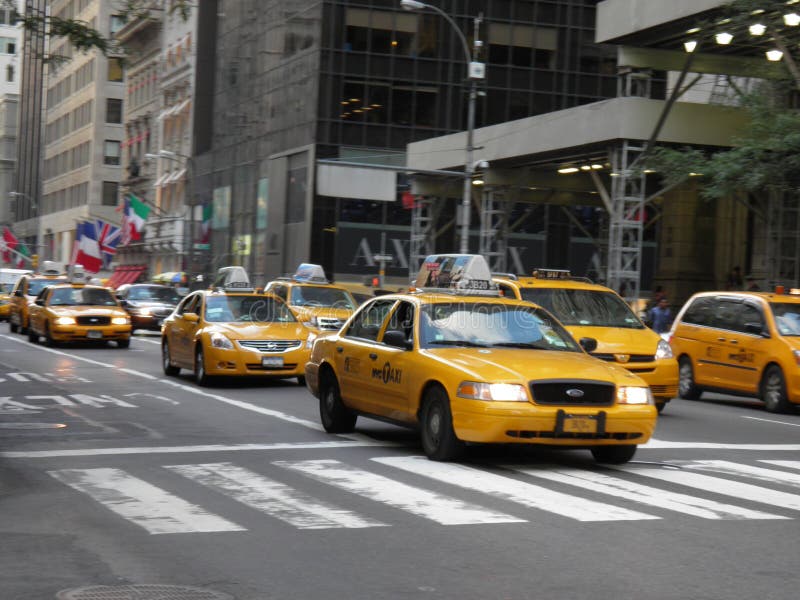 Beroemde gele taxis die in NYC in een mooie dag meeslepen royalty-vrije stock foto Beroemde gele taxis die in NYC in een mooie dag meeslepen royalty-vrije stock foto