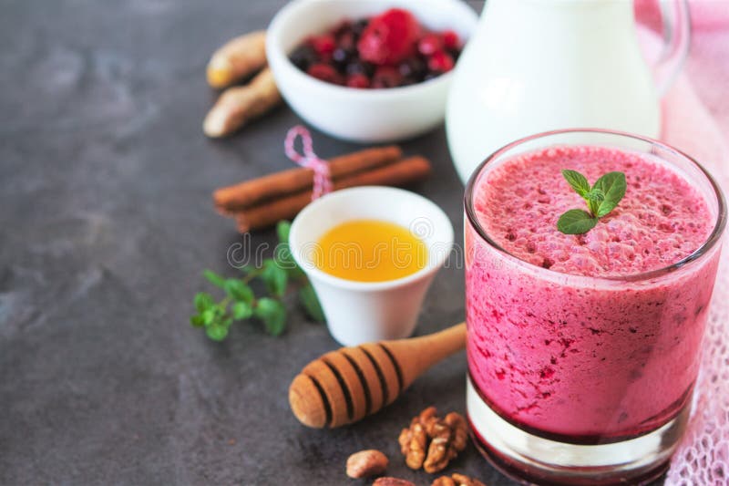Berry fruits smoothie with vegan milk and honey. Summer dessert for well being and healthy lifestyle stock image Berry fruits smoothie with vegan milk and honey. Summer dessert for well being and healthy lifestyle stock image