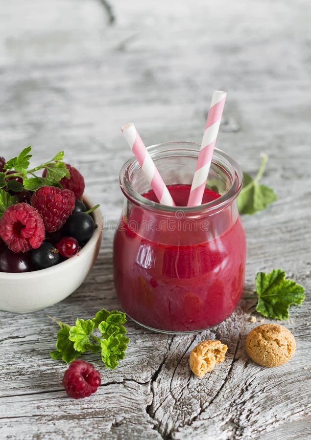 Berry smoothie in a glass jar and berries in a white bowl royalty free stock images Berry smoothie in a glass jar and berries in a white bowl royalty free stock images