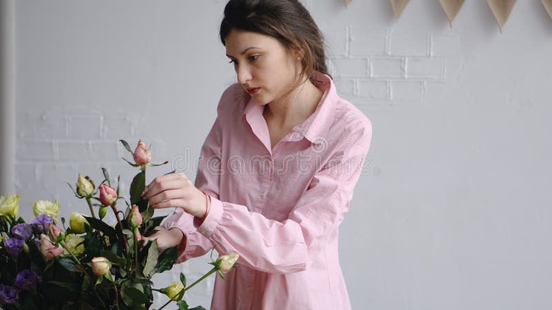 Berufsflorist, der Rosen im Blumenladen vereinbart lizenzfreies stockbild Berufsflorist, der Rosen im Blumenladen vereinbart lizenzfreies stockbild