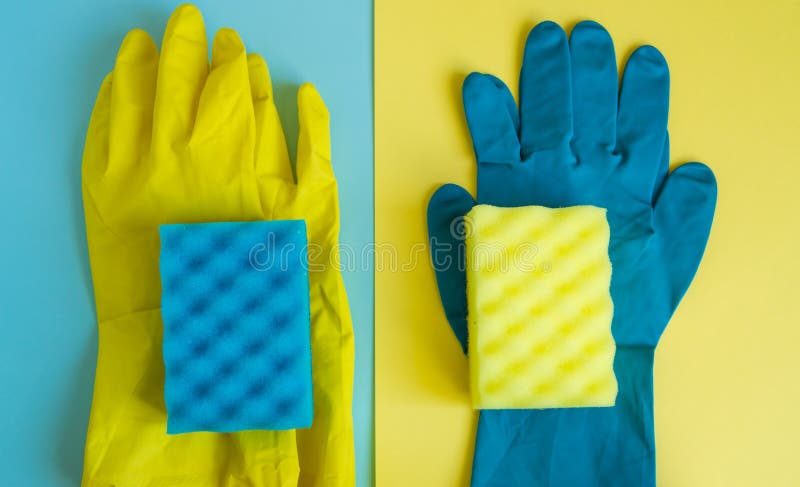 Berufshausreinigungskonzept, Frühjahrsputzzusätze, zwei Paare der Gummihandschuhe und Schwämme auf doppeltem gelb-Blauem lizenzfreies stockbild Berufshausreinigungskonzept, Frühjahrsputzzusätze, zwei Paare der Gummihandschuhe und Schwämme auf doppeltem gelb-Blauem lizenzfreies stockbild