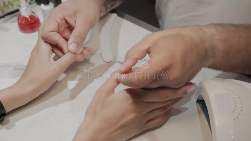 Berufsmeister, der die Finger eines Mädchens nach einem Maniküreverfahren massiert